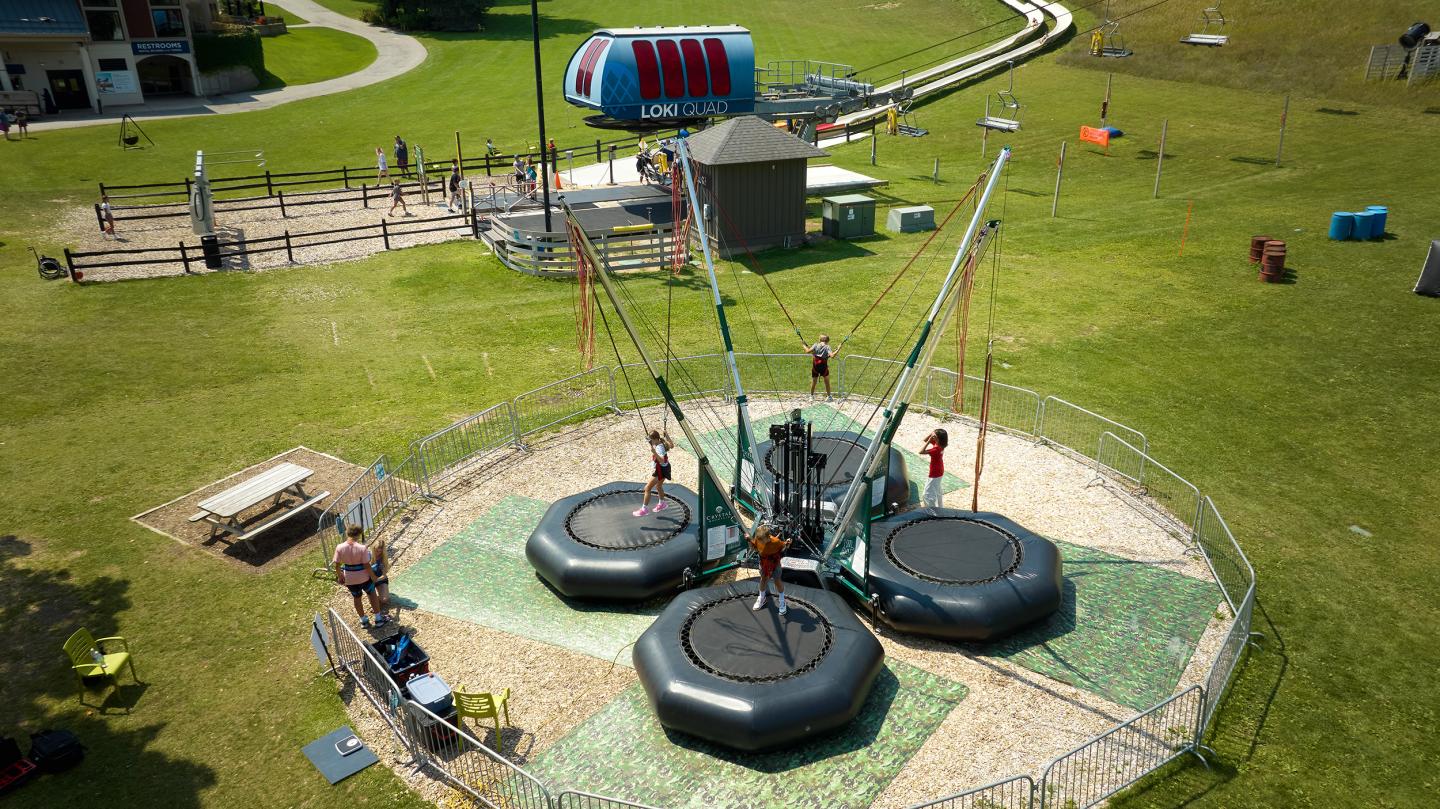 Amusement park bungee trampoline ride on a sunny day.
