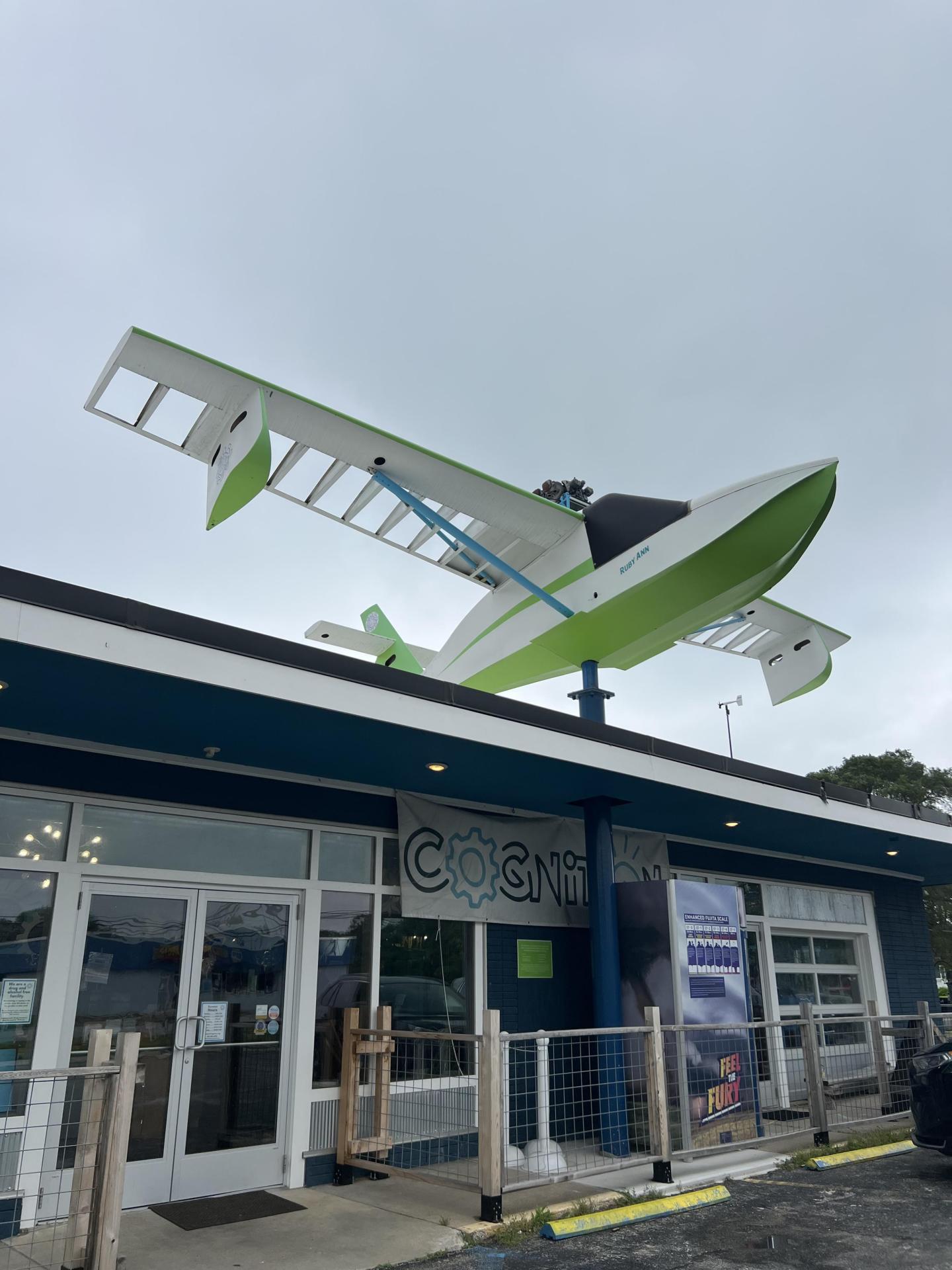 Plane sculpture perched on a building roof.
