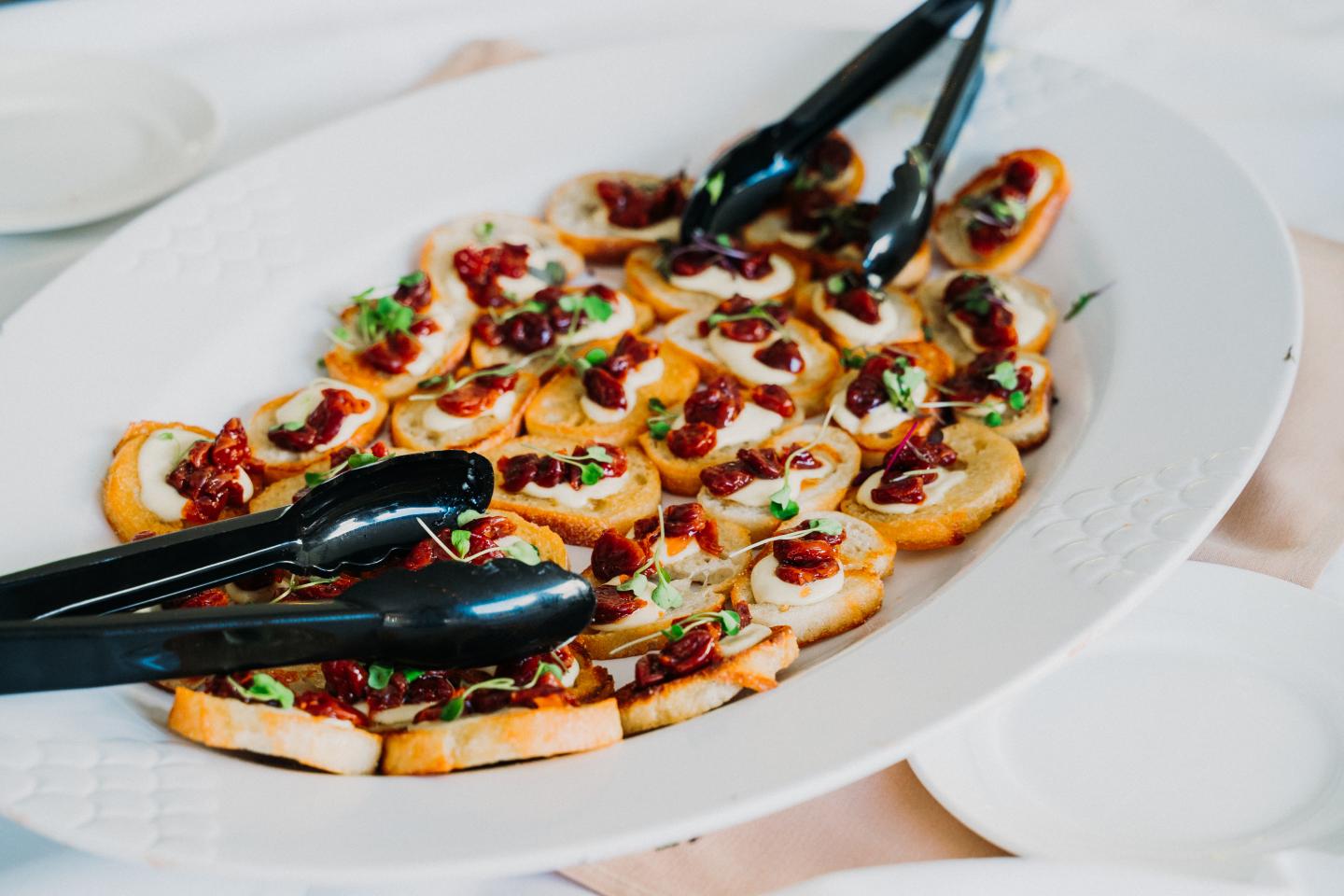 Roasted tomato and fresh basil crostini with Boursin cheese on a platter