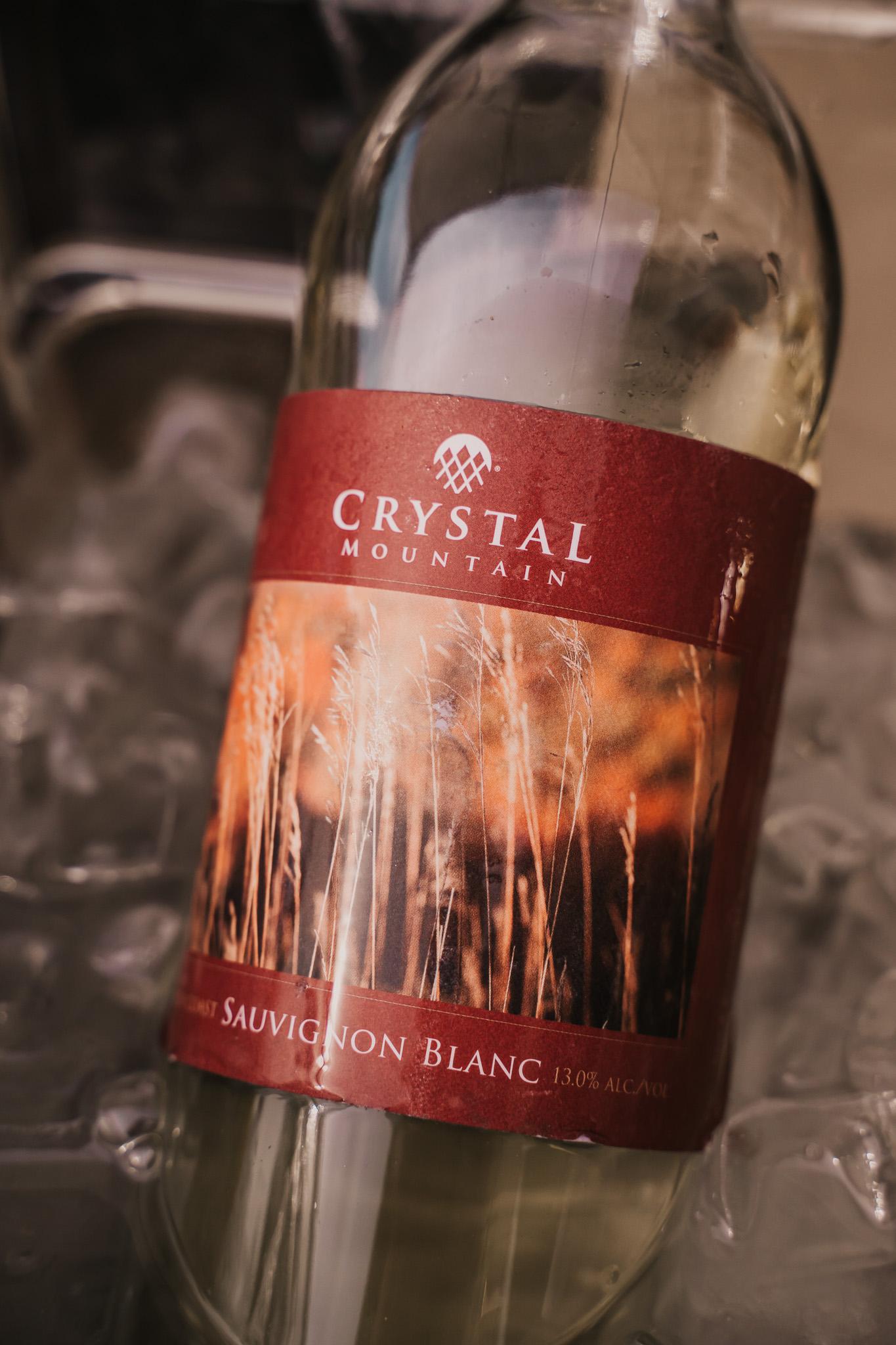 Chilled wine bottle on ice with red label.