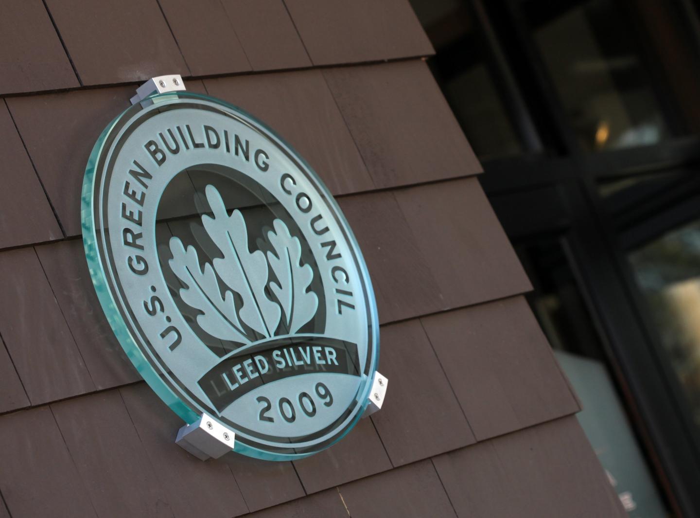 Silver LEED plaque on building, dated 2009.