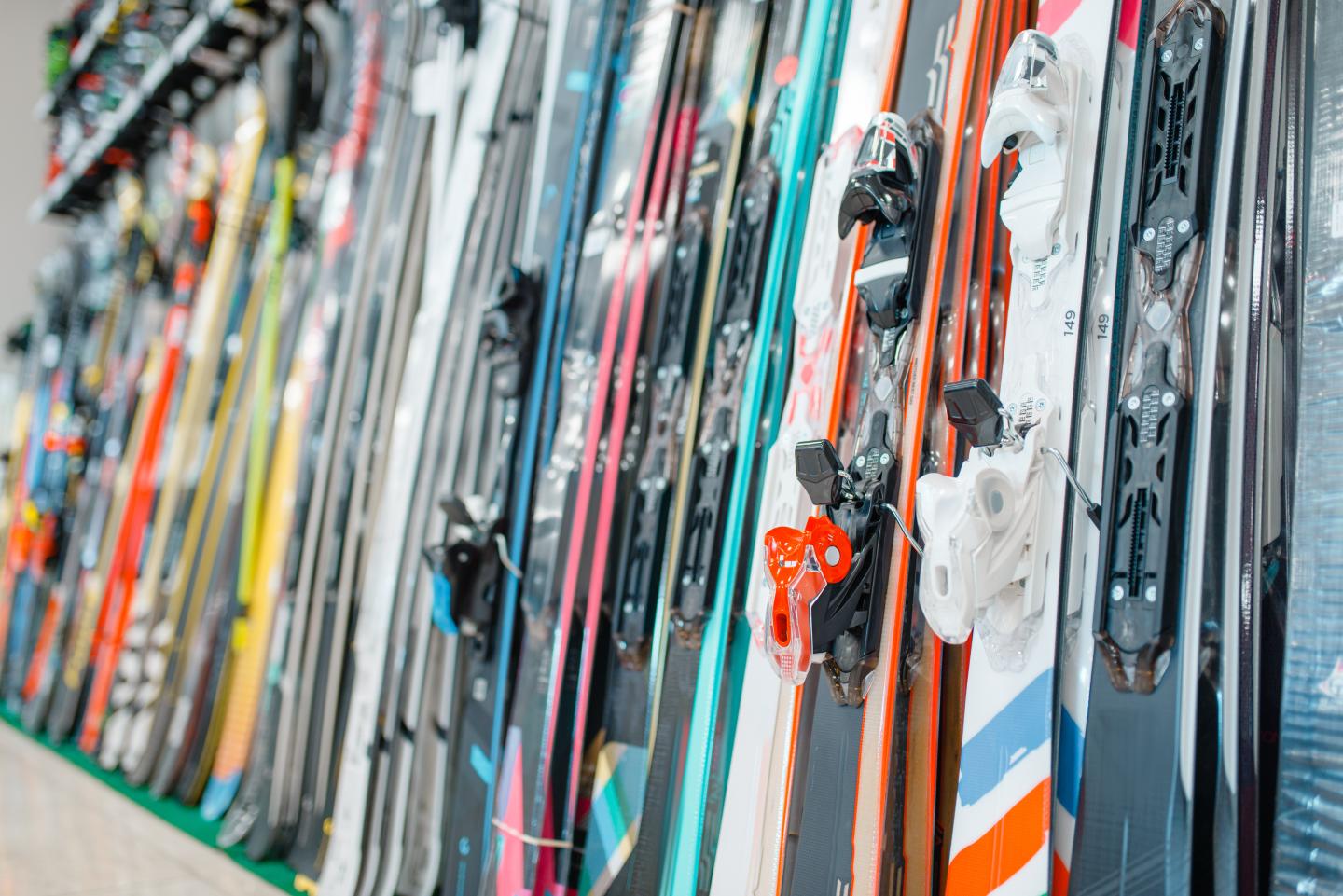 Colorful skis lined up vertically in a shop.