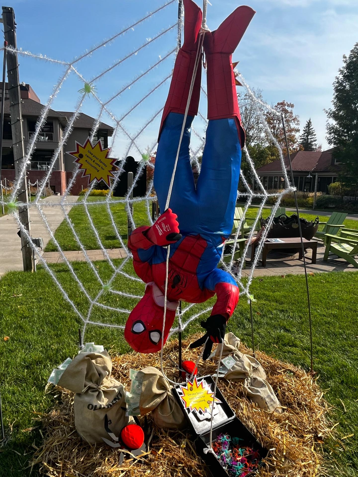 Spider-Man decoration hanging upside down on a large web in Barr Park.