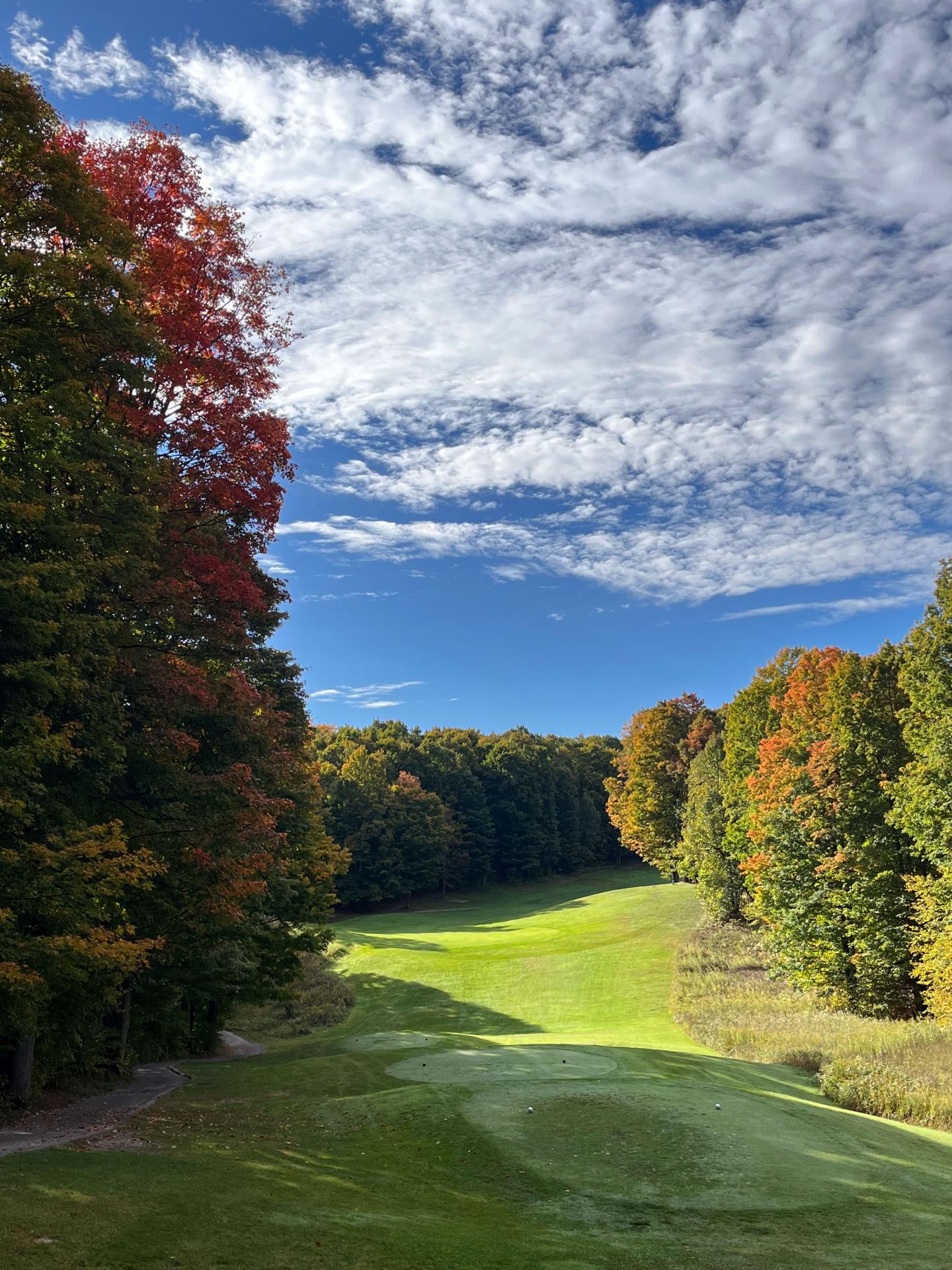 Mountain Ridge golf course with vibrant foliage under a partly cloudy sky.