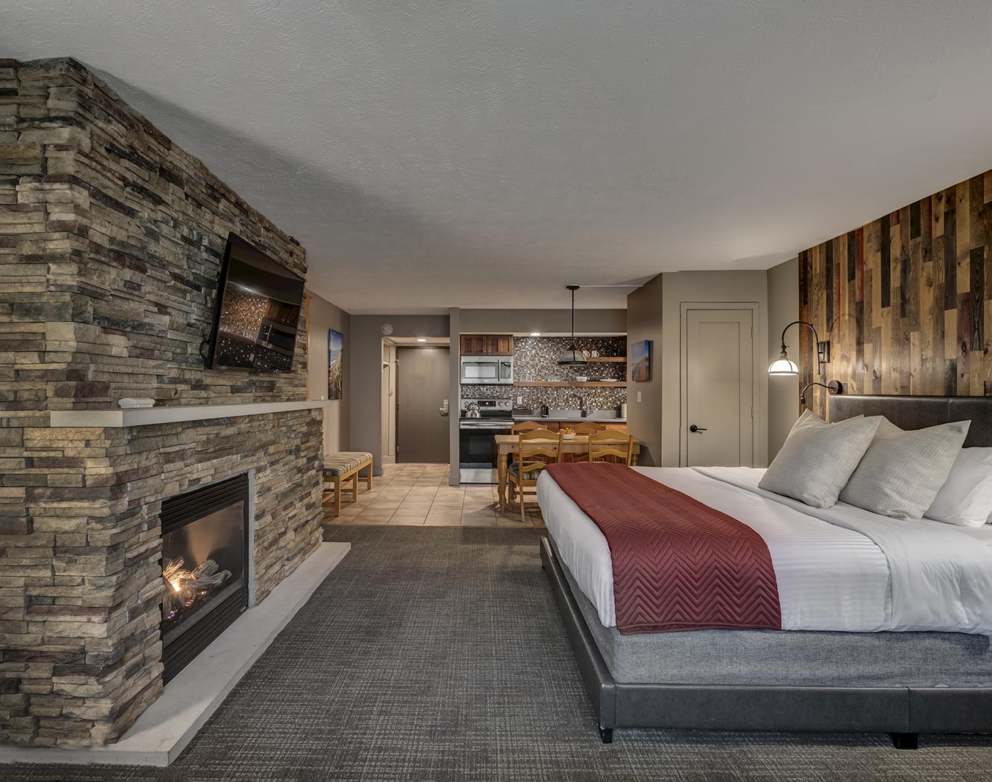 Cozy bedroom with fireplace, TV, and rustic decor.
