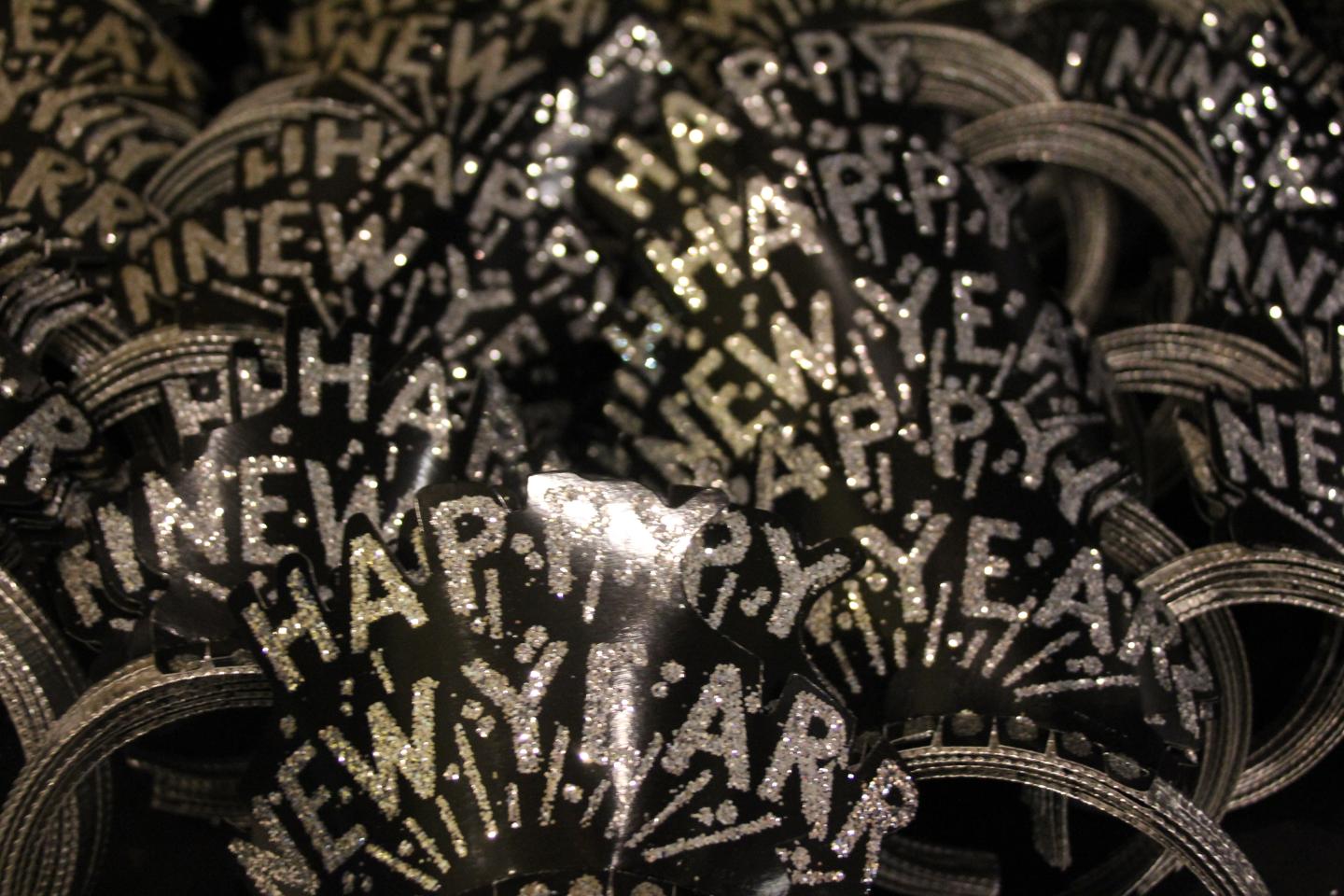 New Year's tiaras with silver glitter letters in a festive pile.