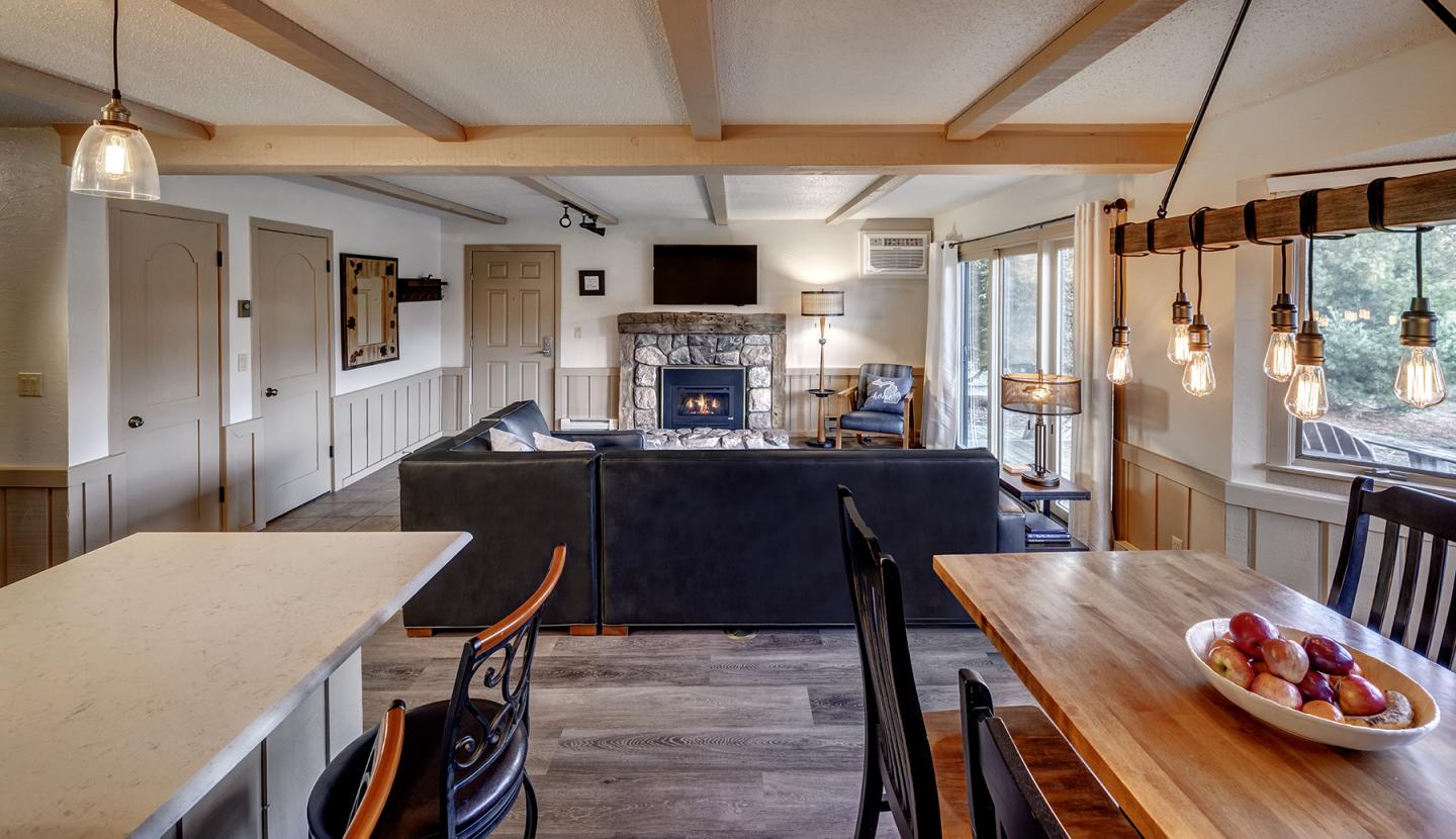 Open-plan living room with sofas, a fireplace, and dining area.