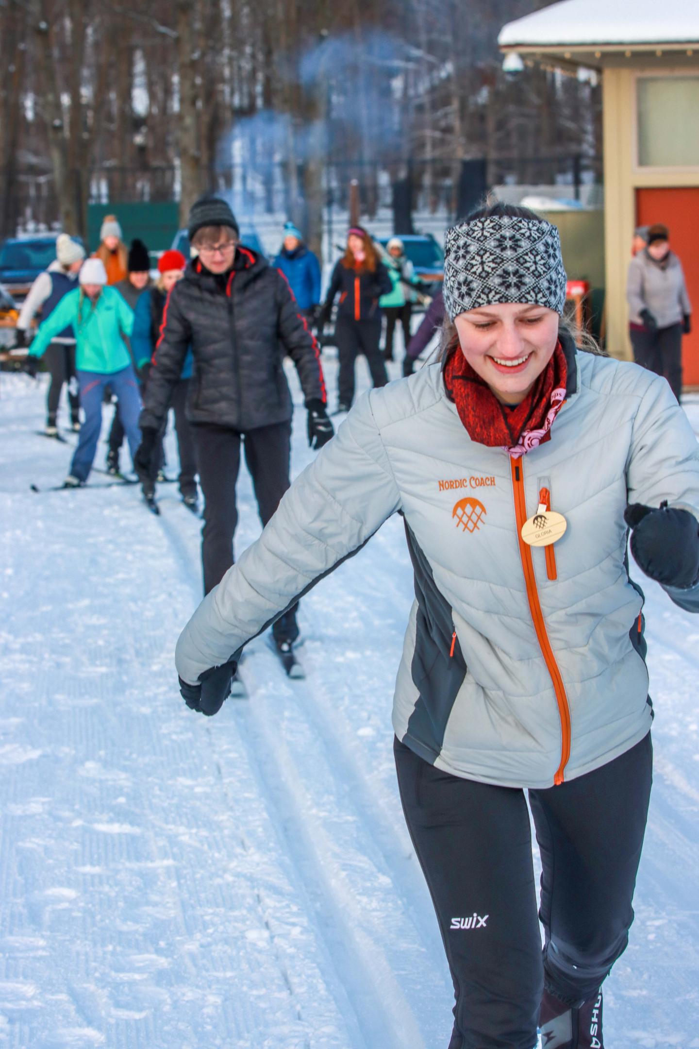 People cross-country skiing on a snowy trail.