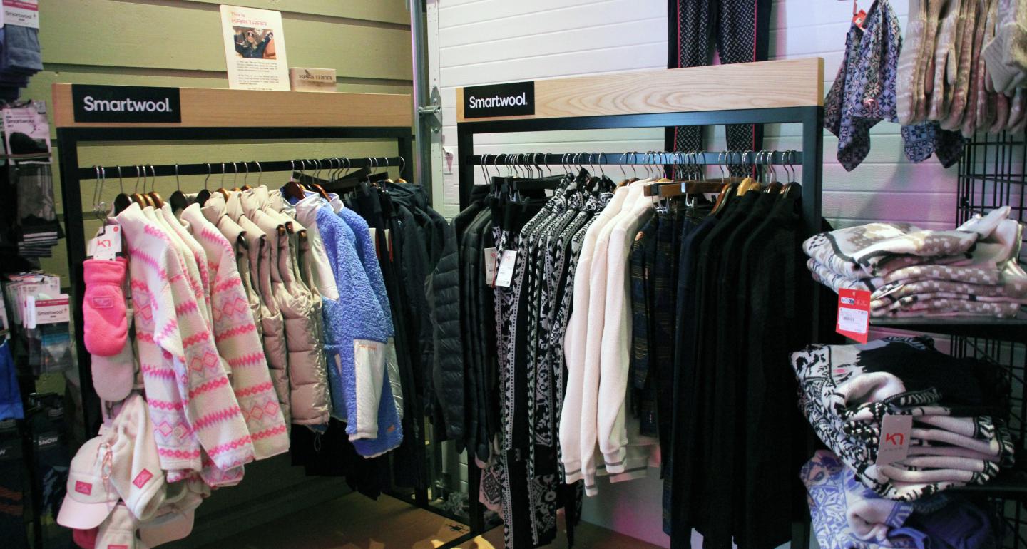 Clothing racks with various patterned jackets and sweaters in a store.
