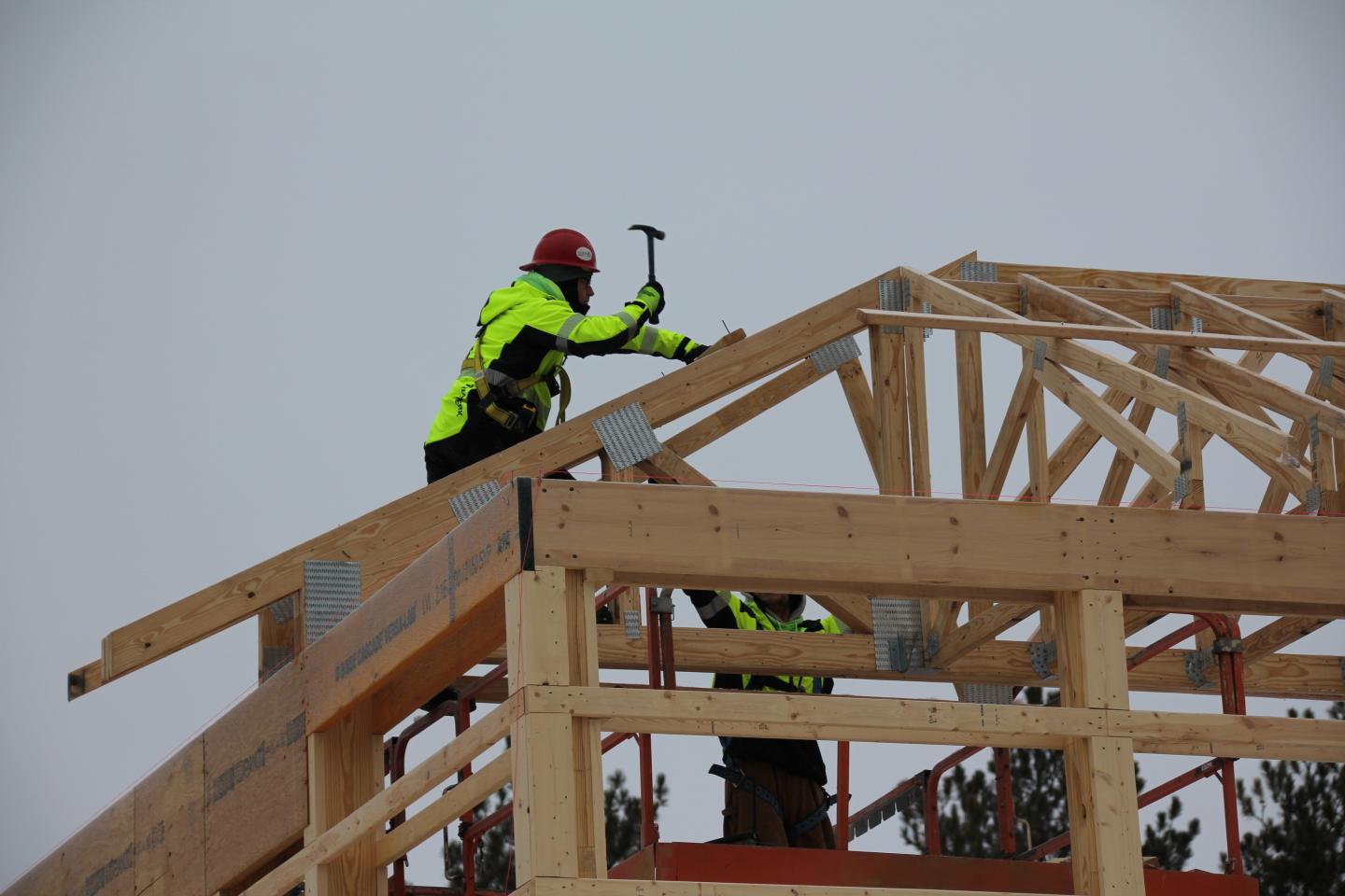 Construction workers building a wooden roof truss.
