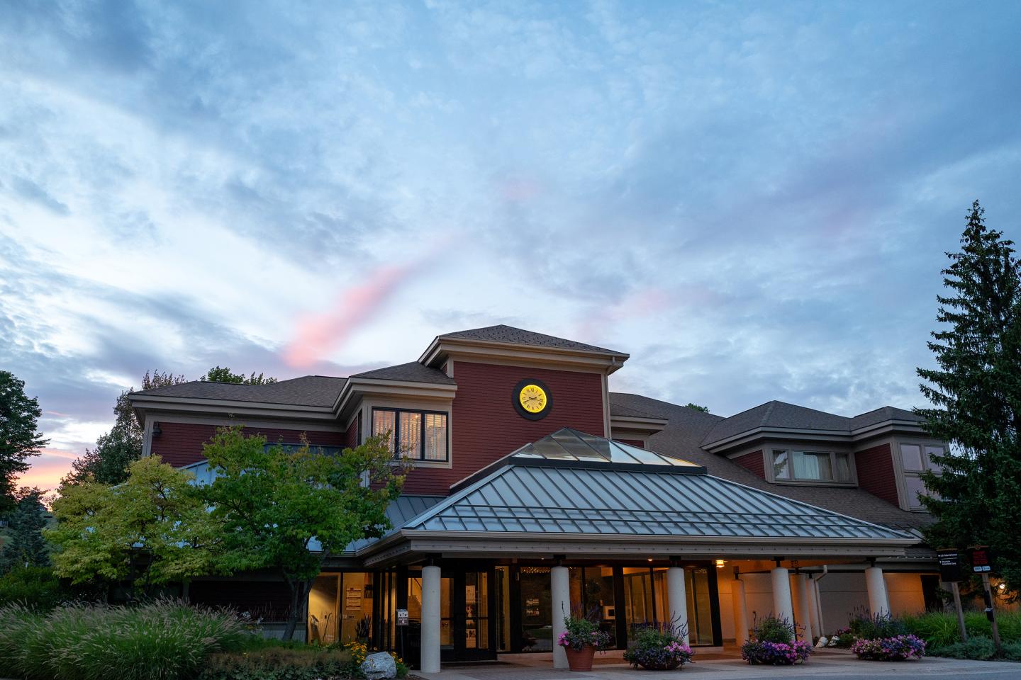 Crystal Center at dusk, surrounded by trees and cloudy sky.