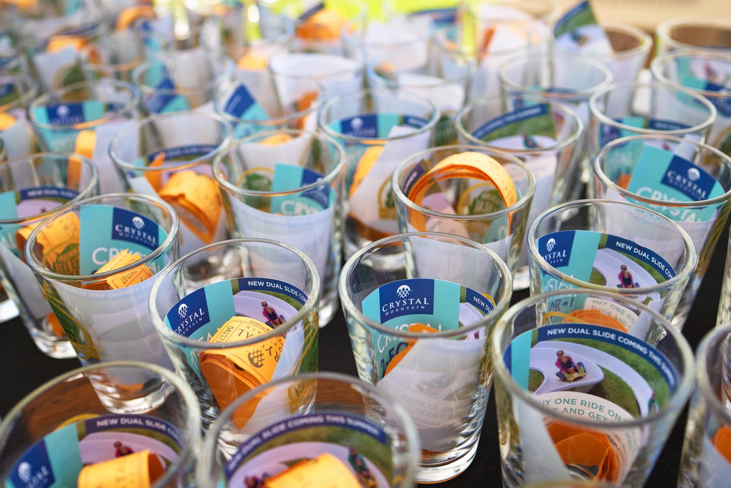 Rows of clear glasses filled with colorful papers and brochures.