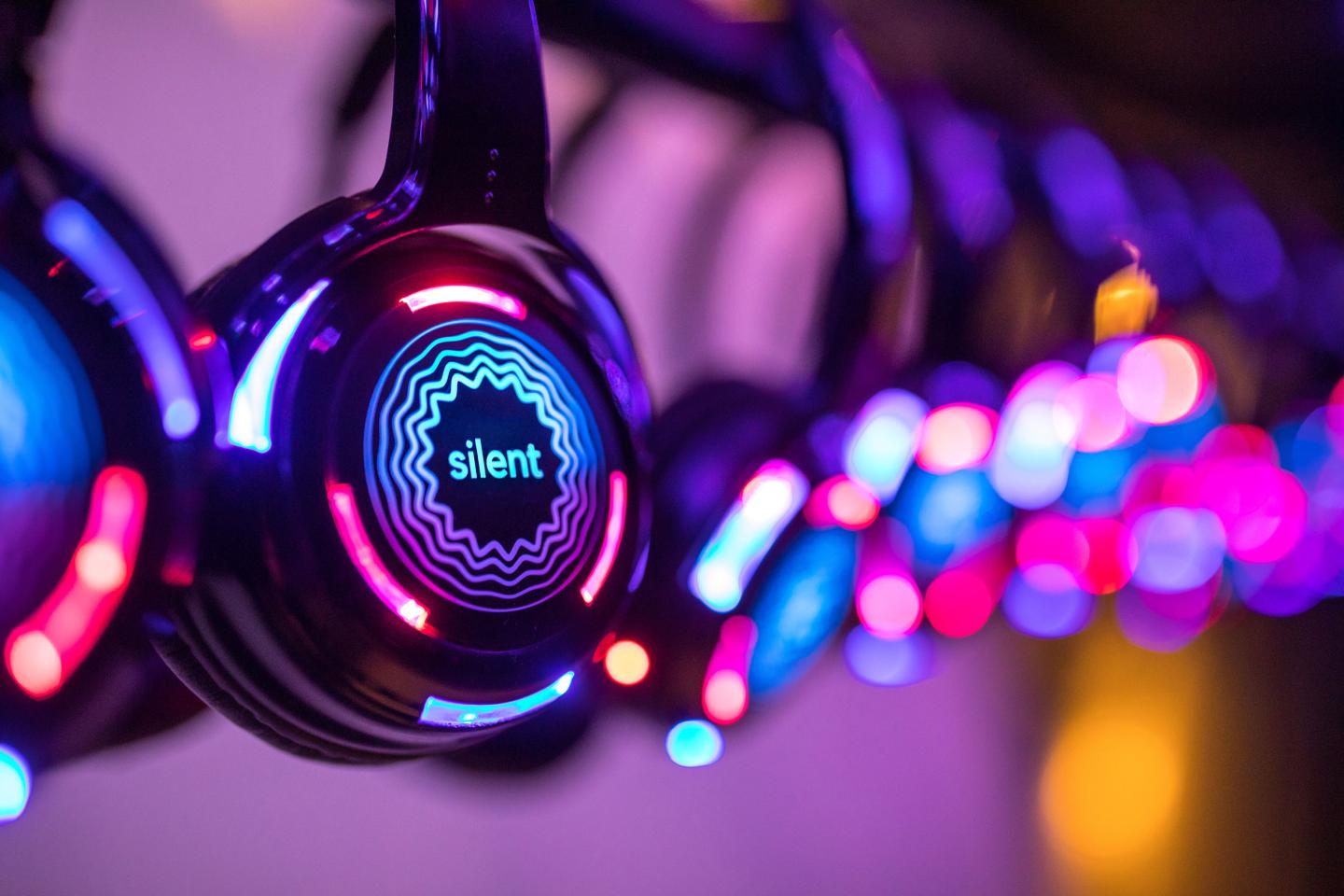 Close-up of illuminated headphones with colorful LED lights in a dark setting.
