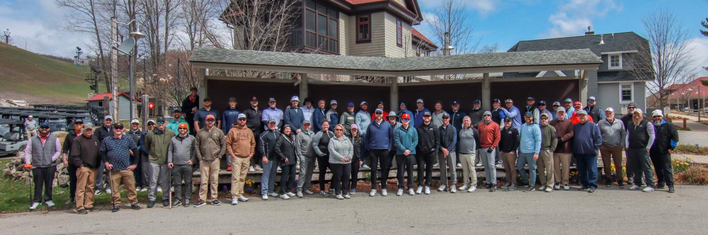 Large group gathered outside before golf outing.
