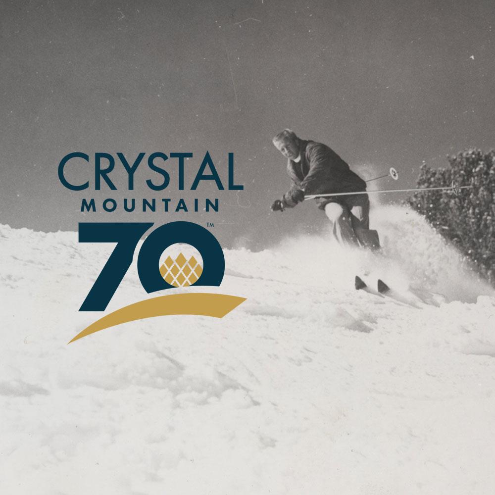 Skier on snowy slope with Crystal Mountain 70 logo.