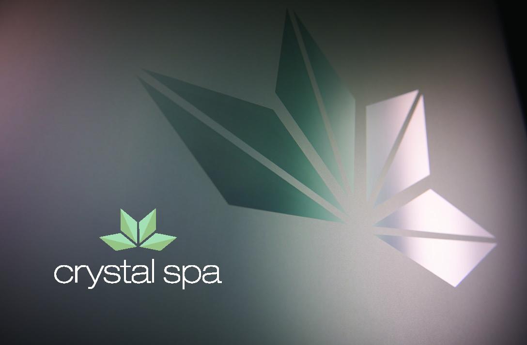 Crystal spa logo with green geometric leaf design.