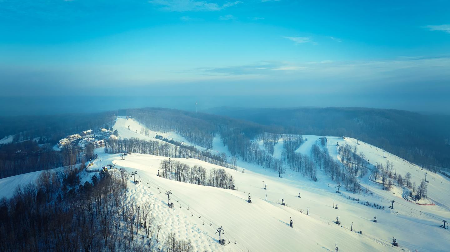 Snow-covered hills under a clear blue sky.